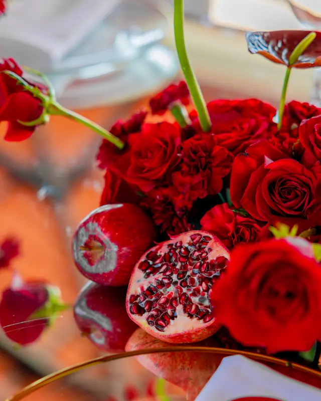 Rosas rojas con granadas sobre la mesa