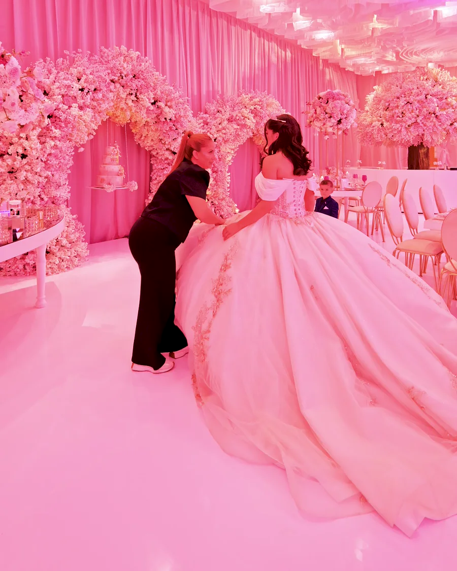 Alguien del equipo acomoda el vestido de la quinceañera antes de su entrada